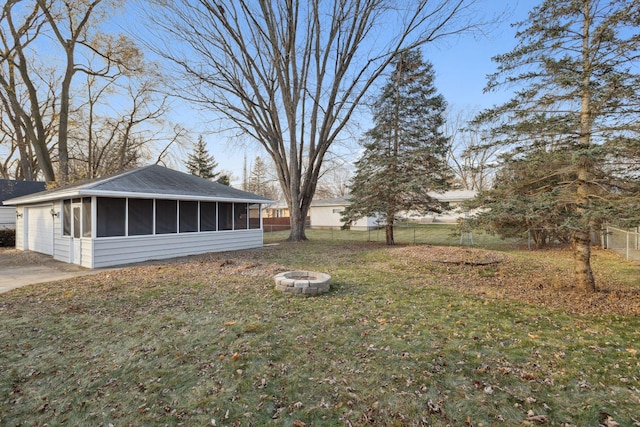 view of yard featuring a sunroom and an outdoor fire pit