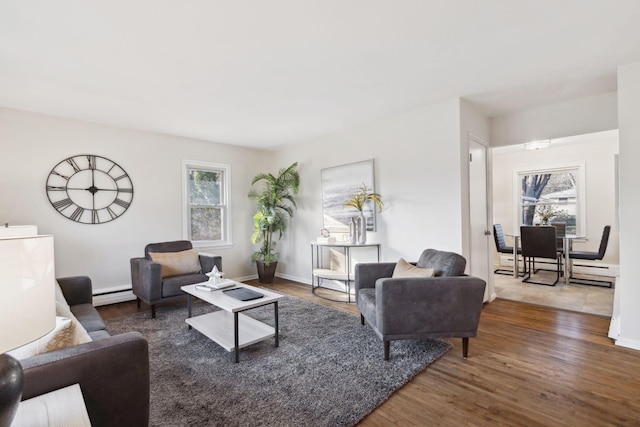 living room with dark wood-type flooring and a baseboard heating unit