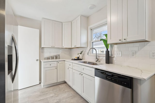 kitchen featuring light stone countertops, appliances with stainless steel finishes, tasteful backsplash, sink, and white cabinetry