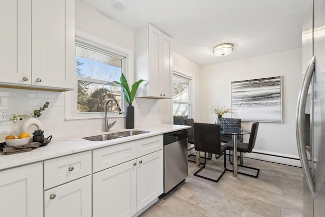 kitchen with sink, light stone countertops, tasteful backsplash, white cabinetry, and stainless steel appliances