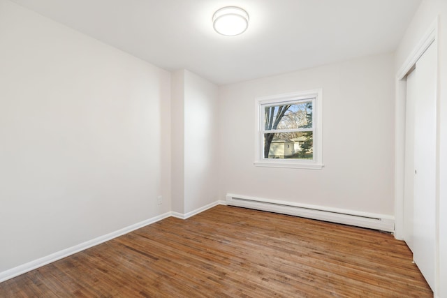 interior space featuring a closet, a baseboard radiator, and wood-type flooring