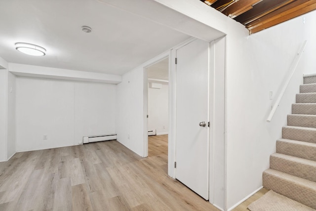 basement featuring light hardwood / wood-style floors and a baseboard radiator