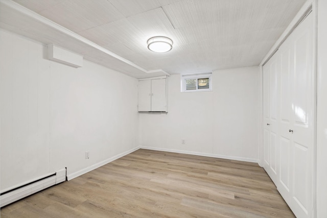 basement with light wood-type flooring and baseboard heating