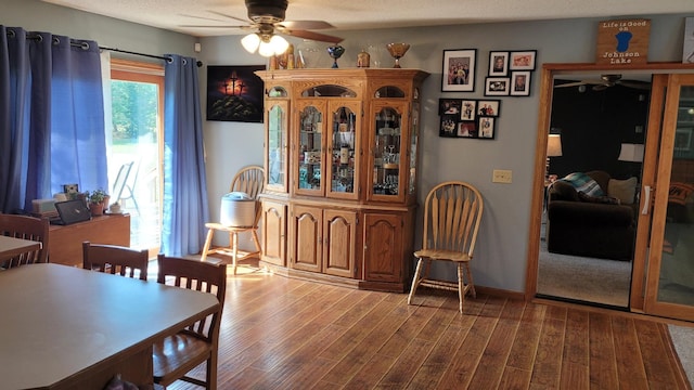 dining room featuring hardwood / wood-style floors, ceiling fan, and a textured ceiling