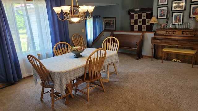 dining area with carpet flooring and a notable chandelier