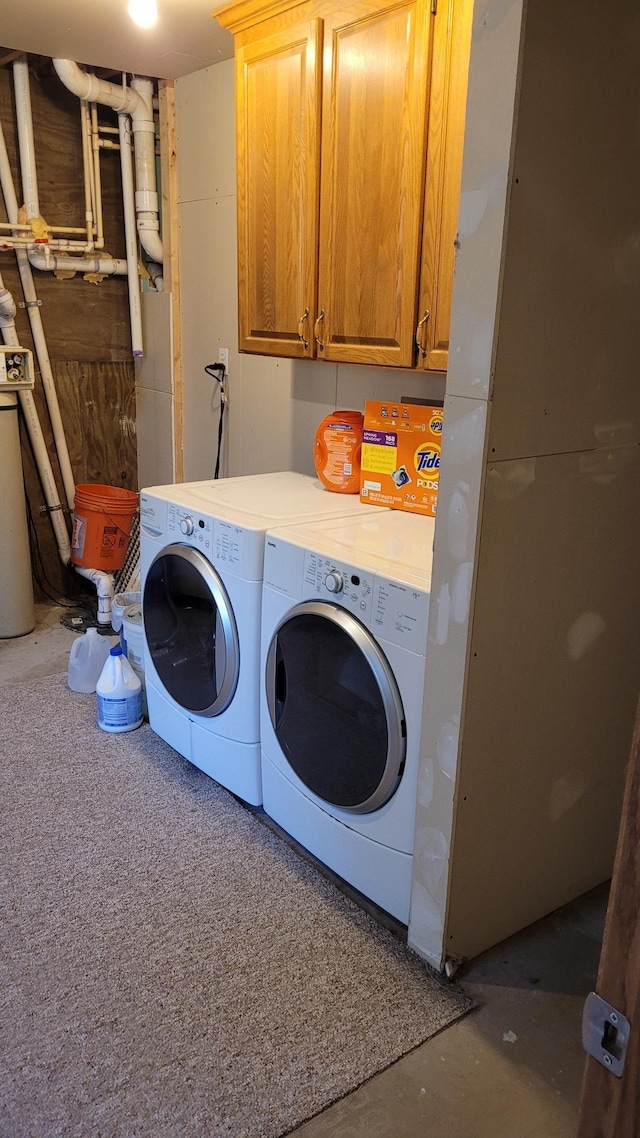 washroom featuring washing machine and dryer and cabinets