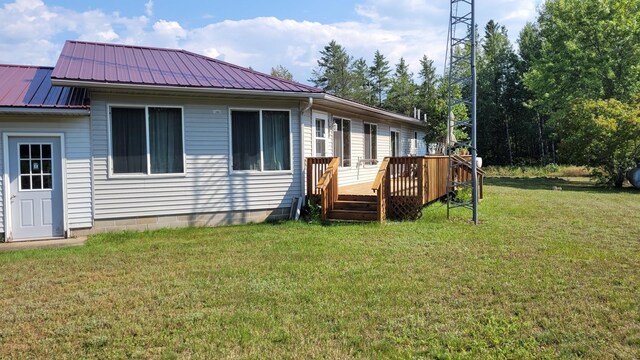 2287 32nd Ave SW, Pine River, MN 56474 - back of house featuring a wooden deck, a lawn, and metal roof