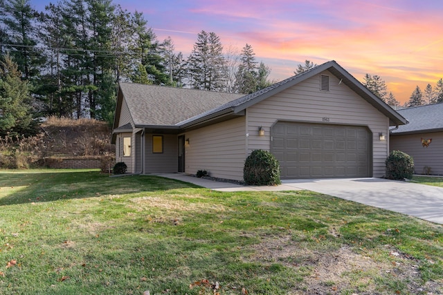 ranch-style home featuring a garage and a yard