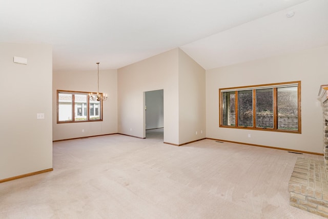 carpeted spare room with vaulted ceiling and an inviting chandelier