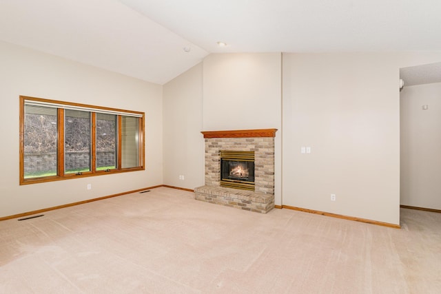 unfurnished living room featuring carpet, a brick fireplace, and vaulted ceiling