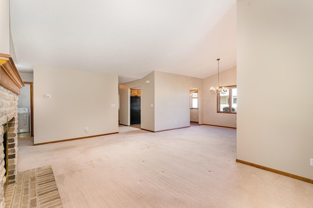 unfurnished living room featuring light carpet, an inviting chandelier, vaulted ceiling, a fireplace, and washer / clothes dryer