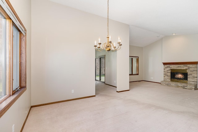 unfurnished living room with light colored carpet, lofted ceiling, a fireplace, and an inviting chandelier