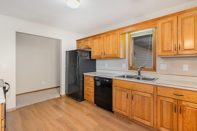 kitchen featuring a textured ceiling, sink, light hardwood / wood-style flooring, and black appliances