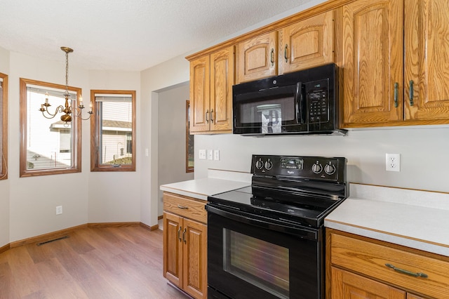 kitchen featuring an inviting chandelier, black appliances, light hardwood / wood-style flooring, a textured ceiling, and decorative light fixtures