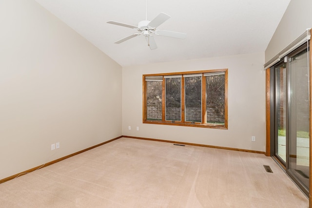 spare room with ceiling fan, light carpet, and vaulted ceiling