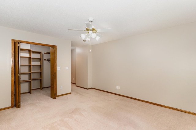 unfurnished bedroom featuring a textured ceiling, light colored carpet, a closet, and ceiling fan