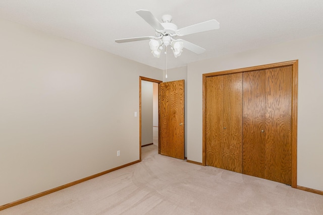 unfurnished bedroom featuring light carpet, a closet, and ceiling fan