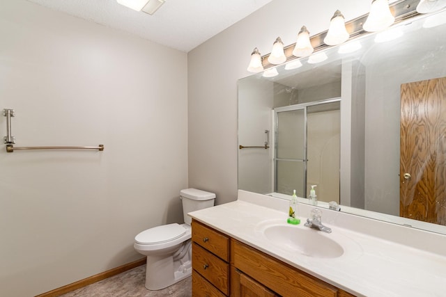 bathroom with toilet, an enclosed shower, a textured ceiling, and vanity