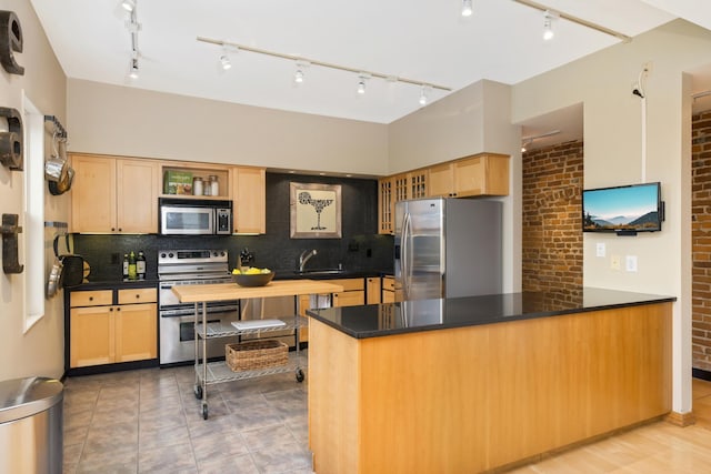 kitchen with kitchen peninsula, decorative backsplash, stainless steel appliances, and brick wall