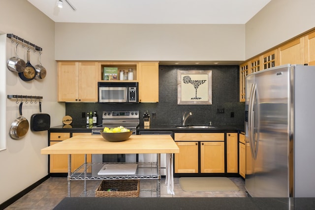 kitchen with light brown cabinets, backsplash, stainless steel appliances, and sink