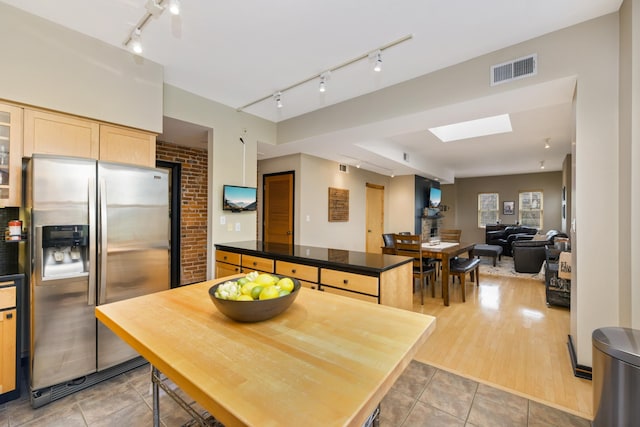 kitchen featuring stainless steel refrigerator with ice dispenser, track lighting, light brown cabinets, hardwood / wood-style floors, and a kitchen island