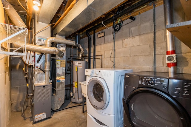 clothes washing area featuring washing machine and dryer and water heater