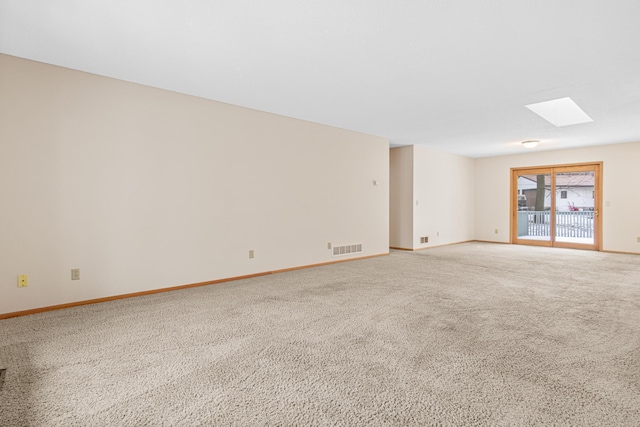 unfurnished room with carpet flooring and a skylight