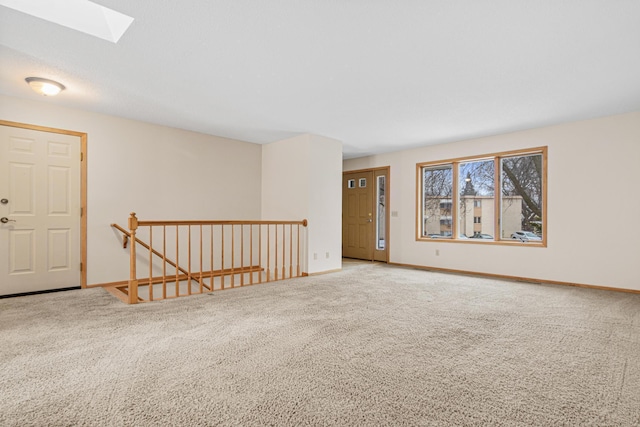 empty room with carpet flooring and a skylight