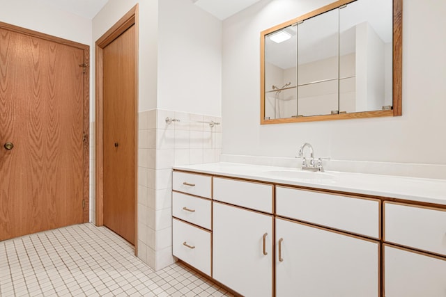 bathroom with tile patterned floors, vanity, and tile walls