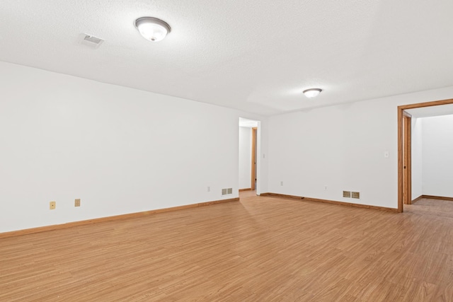 unfurnished room featuring a textured ceiling and light wood-type flooring