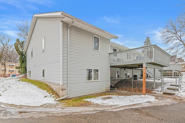 view of snowy exterior featuring a wooden deck