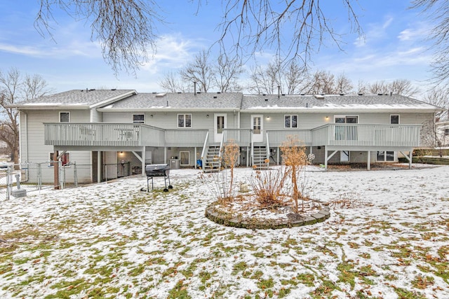 snow covered back of property featuring central air condition unit and a wooden deck