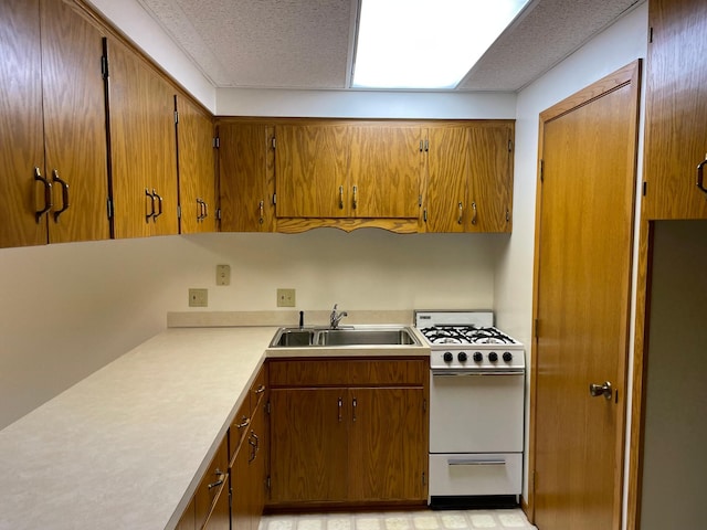 kitchen featuring white range with gas stovetop and sink