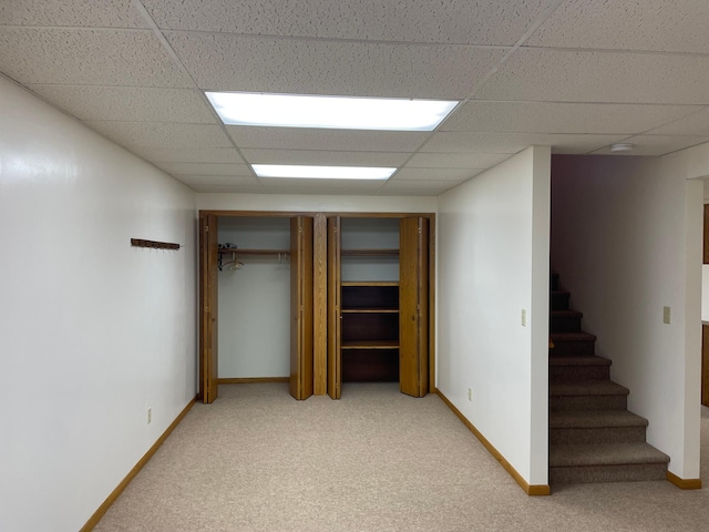 basement with carpet flooring and a drop ceiling