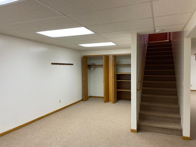 basement with a drop ceiling and carpet