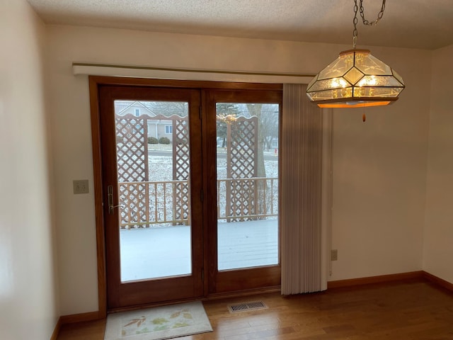 doorway featuring hardwood / wood-style floors and a textured ceiling