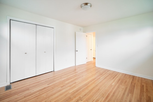 unfurnished bedroom with a closet and light hardwood / wood-style flooring