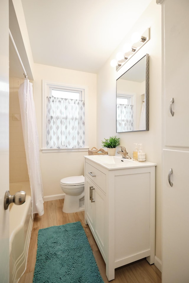 full bathroom with vanity, hardwood / wood-style flooring, and plenty of natural light