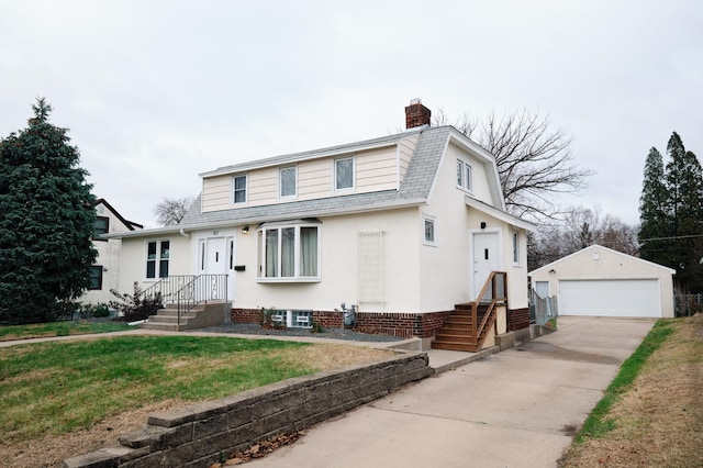 view of front of property with a front yard, an outdoor structure, and a garage