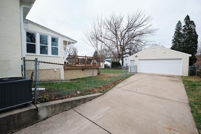 view of side of property with a lawn, central AC, a wooden deck, a garage, and an outbuilding