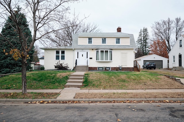 front of property with a front yard, an outbuilding, and a garage