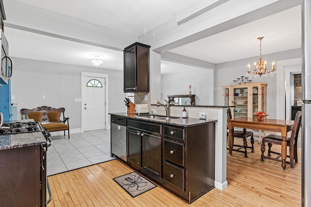 kitchen with dark stone countertops, sink, dark brown cabinetry, and dishwasher