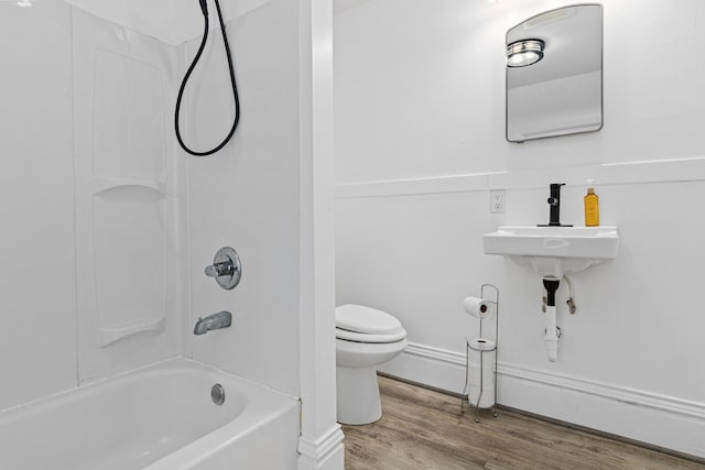 bathroom with shower / bath combination, wood-type flooring, and toilet