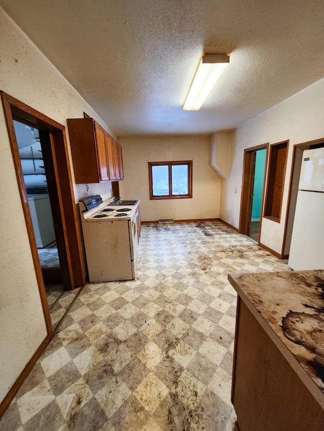 kitchen with a textured ceiling and white appliances