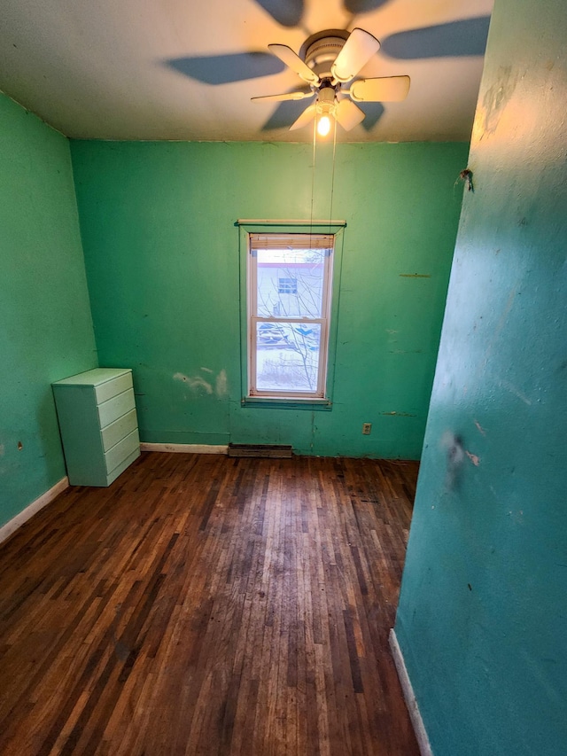 empty room with ceiling fan and dark wood-type flooring