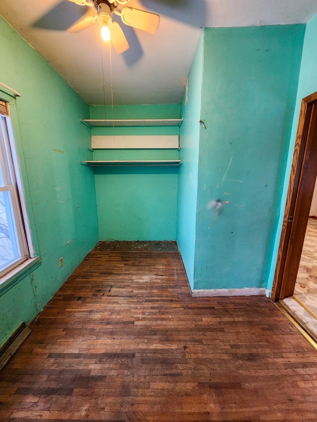 unfurnished bedroom featuring dark hardwood / wood-style floors, ceiling fan, and baseboard heating