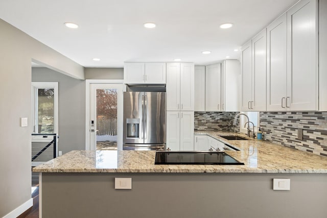 kitchen with light stone countertops, white cabinets, and stainless steel fridge with ice dispenser