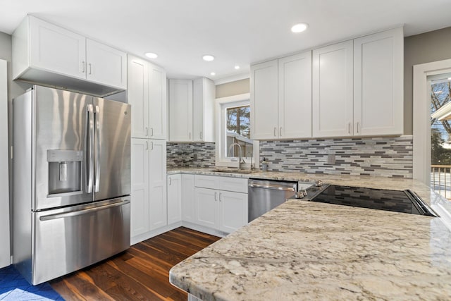 kitchen featuring tasteful backsplash, appliances with stainless steel finishes, dark wood-style flooring, light stone countertops, and white cabinetry