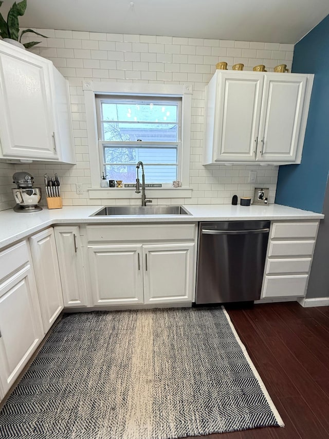 kitchen featuring white cabinets, sink, stainless steel dishwasher, dark hardwood / wood-style floors, and tasteful backsplash