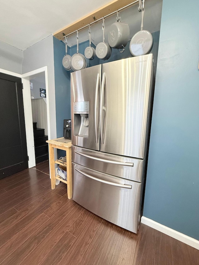 kitchen with dark wood finished floors, baseboards, and stainless steel fridge